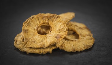 Pineapple rings (dried) on a vintage slate slab as detailed close-up shot, selective focus