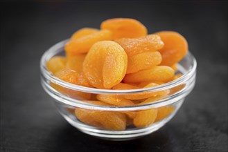 Portion of Dried Food (Apricots) as detailed close up shot on a slate slab (selective focus)