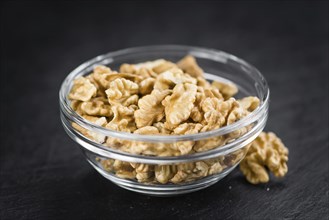 Portion of Cracked Walnuts on a rustic slate slab (selective focus, close-up shot)