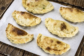 Portion of healthy Empanadas on an old wooden table (selective focus, close-up shot)