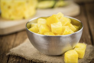 Sliced Pineapple on an old wooden table as detailed close-up shot, selective focus