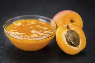 Portion of Apricot Jam as detailed close up shot on a slate slab (selective focus)