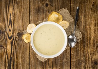 Chanterelle Soup as high detailed close-up shot on a vintage wooden table, selective focus