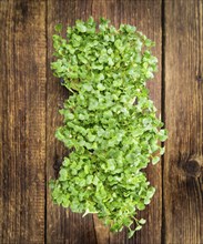 Fresh Cress as high detailed close-up shot on a vintage wooden table (selective focus)