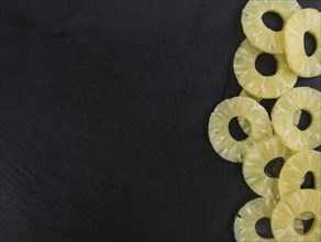 Some fresh Preserved Pineapple Rings on a vintage slate slab, selective focus, close-up shot