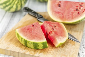 Fresh Watermelon as high detailed close-up shot on a vintage wooden table (selective focus)