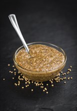 Some German Cuisine (sweet Mustard) on a slate slab (close-up shot, selective focus)