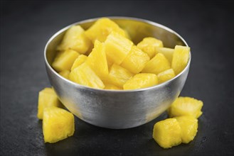 Portion of Sliced Pineapple as detailed close up shot on a slate slab, selective focus