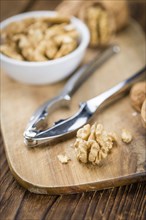 Cracked Walnuts as high detailed close-up shot on a vintage wooden table (selective focus)