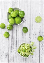 Sliced Limes on rustic wooden background (close-up shot)