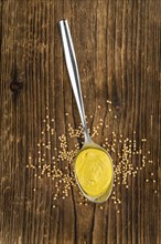 Portion of homemade Mustard on wooden background (selective focus, close-up shot)