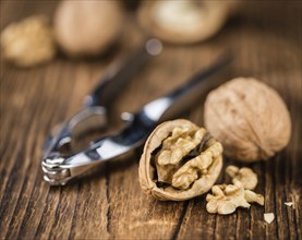 Walnuts on rustic wooden background (close-up shot)