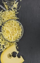 Homemade Grated Cheese (close-up shot) on a vintage slate slab