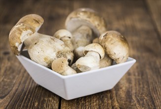 Wooden table with some fresh Porcinis as detailed close-up shot (selective focus)