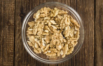 Cracked Walnuts as high detailed close-up shot on a vintage wooden table (selective focus)