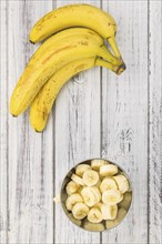 Sliced Bananas on an old wooden table as detailed close-up shot, selective focus