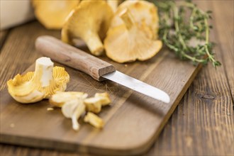 Portion of fresh harvested Chanterelles on wooden background as detailed close-up shot (selective