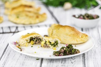 Wooden table with fresh homemade Empanadas (detailed close-up shot, selective focus)