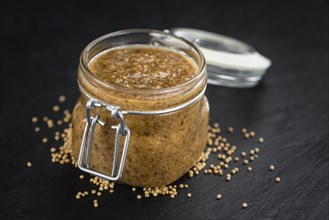 Portion of Mustard (sweet) as detailed close up shot on a slate slab (selective focus)