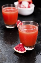 Some freshly squeezed Grapefruit Juice on a vintage background (close-up shot, selective focus)