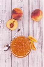 Homemade Peach Jam on an wooden table as detailed close-up shot, selective focus