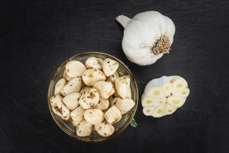 Marinated Garlic on a vintage slate slab (close-up shot, selective focus)