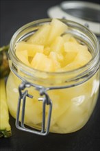 Portion of Chopped Pineapple (preserved) on a rustic slate slab, selective focus, close-up shot