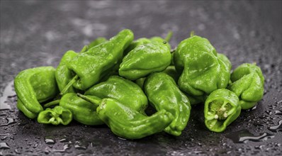 Portion of Raw Pimientos on a rustic slate slab, selective focus, close-up shot