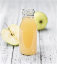 Apple Juice on an old wooden table as detailed close-up shot (selective focus)