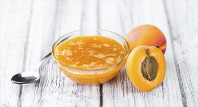 Apricot Jam on an old wooden table as detailed close-up shot (selective focus)