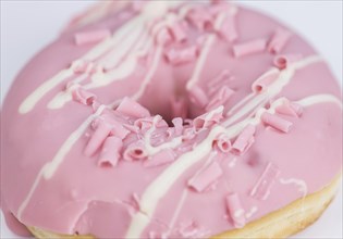 Portion of pink glazed Donuts (detailed close-up shot)