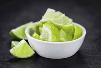 Sliced Limes on a vintage slate slab (close-up shot, selective focus)