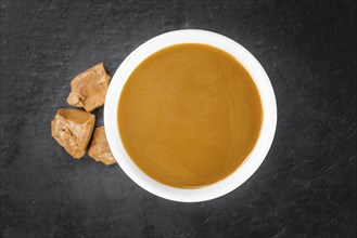 Portion of fresh Caramel Sauce (close-up shot, selective focus)