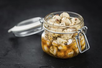 Portion of Garlic (preserved) on a rustic slate slab (selective focus, close-up shot)