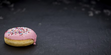 Portion of pink glazed Donuts (detailed close-up shot)