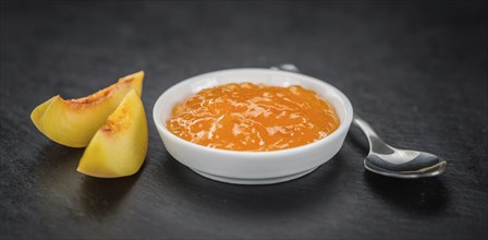 Peach Jam on a vintage slate slab as detailed close-up shot, selective focus