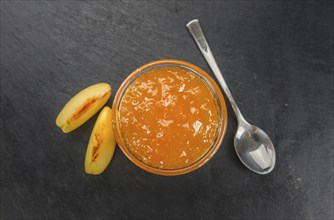 Portion of Peach Jam on a rustic slate slab, selective focus, close-up shot