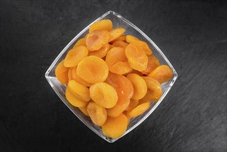 Portion of Dried Food (Apricots) as detailed close up shot on a slate slab (selective focus)