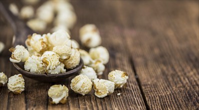 Popcorn as high detailed close-up shot on a vintage wooden table, selective focus