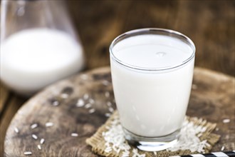 Wooden table with Rice Milk (detailed close-up shot, selective focus)