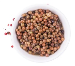 Portion of preserved Pink Peppercorns as detailed close-up shot isolated on white background