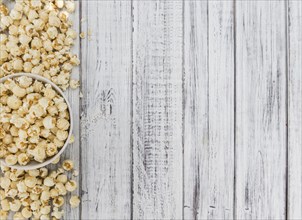 Fresh made Popcorn on a vintage background as detailed close-up shot