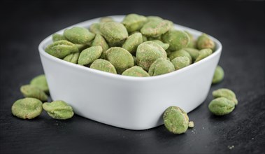 Homemade Peanuts (with Wasabi flavor) on vintage background (selective focus, close-up shot)