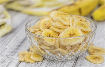 Dried Banana Chips on a vintage background as detailed close-up shot, selective focus