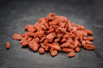 Portion of Dried Goji Berries on a rustic slate slab (selective focus, close-up shot)