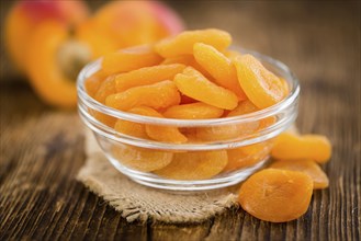 Dried Food (Apricots) on rustic wooden background (close-up shot)