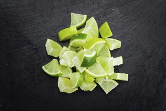 Sliced Limes on a vintage slate slab (close-up shot, selective focus)