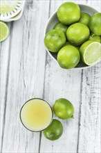 Fresh made Fresh Lime Juice on an old and rustic wooden table (selective focus, close-up shot)