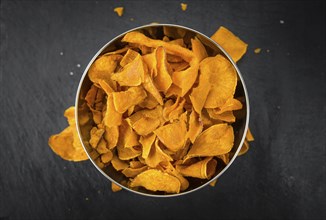 Some fresh Sweet Potato Chips on a vintage slate slab, selective focus, close-up shot