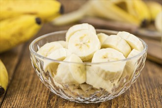 Sliced Bananas on an old wooden table as detailed close-up shot, selective focus